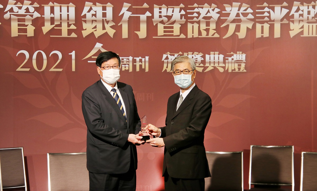 兆豐銀行榮獲今周刊2021年財富管理銀行暨證券評鑑「最佳客戶滿意獎」首獎及「最佳理專團隊獎」、「最佳銀色友善獎」等三大獎；兆豐銀行總經理蔡永義(左)從金管會主委黃天牧(右)手中接獲榮耀獎盃。