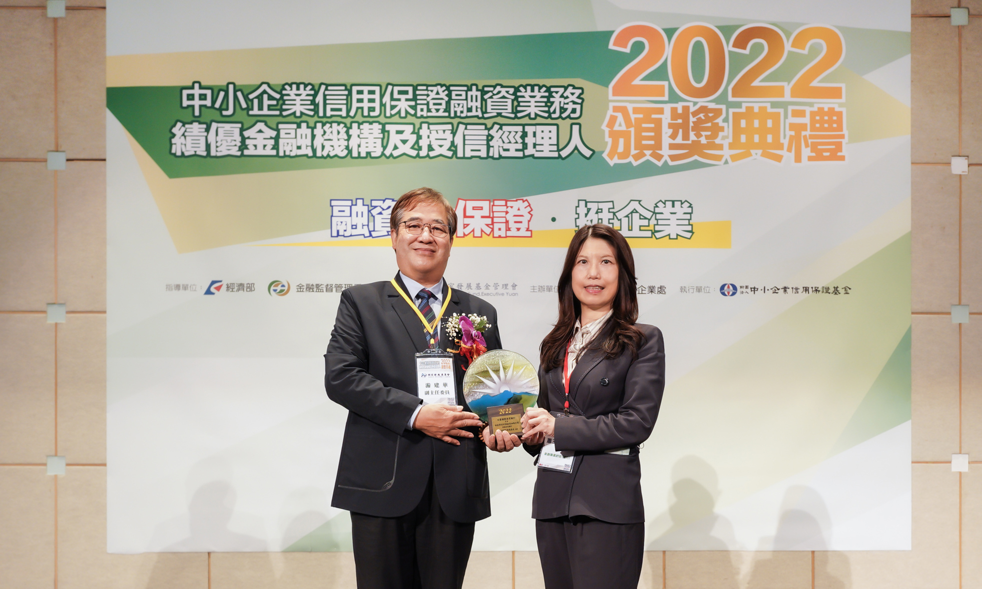 兆豐銀行榮獲「2022新創事業紓困融資加碼方案績優授信銀行」等四座獎項，由國發會副主委游建華(左)頒發，兆豐銀行副總經理蕭玉美(右)代表領獎。