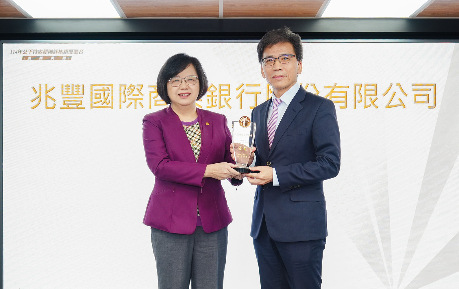 兆豐銀行獲公平待客銀行業前25%績優，今(4)日由金管會主委彭金隆(右)頒獎，兆豐銀行總經理黃永貞(左)代表受獎。
